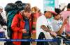 JOHN WOODS / FREE PRESS
                                Daniel Schenkeveld, left, tries to rebook his flight on his phone as he lines up with other WestJet passengers trying to rebook their cancelled flights at Winnipeg airport Monday.
