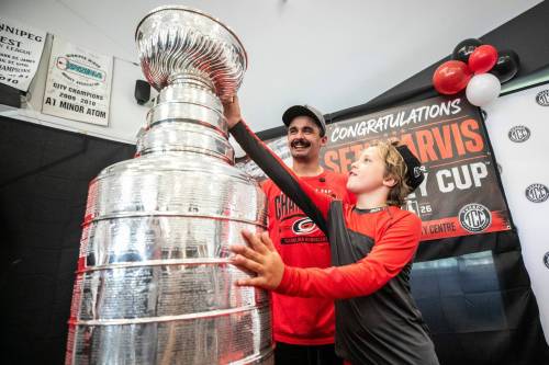 MIKAELA MACKENZIE / FREE PRESS
                                Winnipeg&rsquo;s Seth Jarvis poses for a photo with nine-year-old Jack Dobson and the Stanley Cup at the Tuxedo Community Centre on Monday.