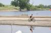 A cyclist is reflected in the flood waters off First Street North on July 27 in Brandon. (Matt Goerzen/The Brandon Sun)