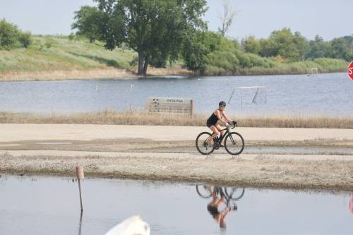 A cyclist is reflected in the flood waters off First Street North on July 27 in Brandon. (Matt Goerzen/The Brandon Sun)