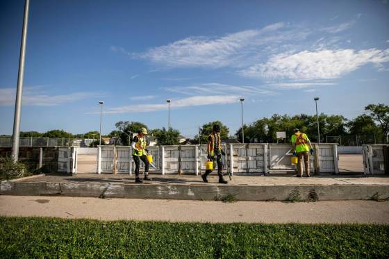 City crew members Tee Silver (left), Alex Cloney and Kyle Bergantim clean up needles and other hazardous materials at Freight House park. (Mikaela MacKenzie / Free Press)