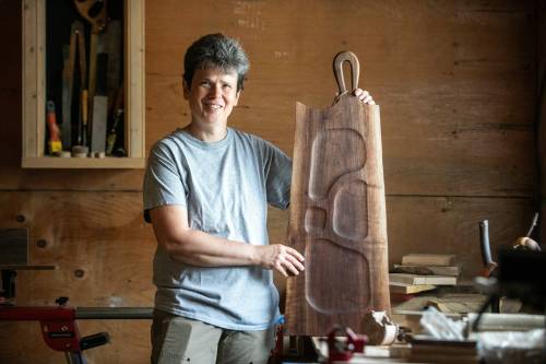 MIKAELA MACKENZIE / FREE PRESS
                                Woodworker Marina Bulan with one of her charcuterie boards in her workshop on Monday.