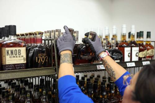 BRANDON SUN FILES
A liquor mart employee helps stock American alcohol onto shelves