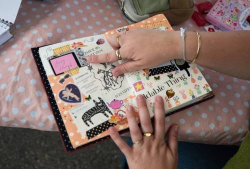 ROBERT LEE / FREE PRESS
                                Artist and facilitator Katie Borgfjord shows off one of her journals at Scrap & Yap, an arts-and-crafts collage group that has been setting up a table at the Riverview market on Monday.