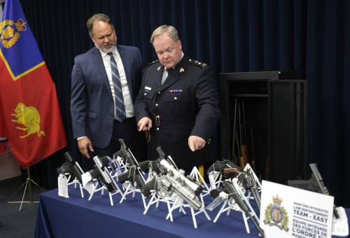 RUTH BONNEVILLE / FREE PRESS
                                At a news conference Tuesday, RCMP Supt. Jeff Asmundson and Manitoba Justice Minister Matt Wiebe look over the large amount of guns and drugs confiscated during a nearly tw0-year investigation.