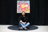Toronto Blue Jays pitcher Dylan Cease sits under his painting during an event at the Art Gallery of Ontario in Toronto, Tuesday, August 25, 2026. THE CANADIAN PRESS/Cole Burston