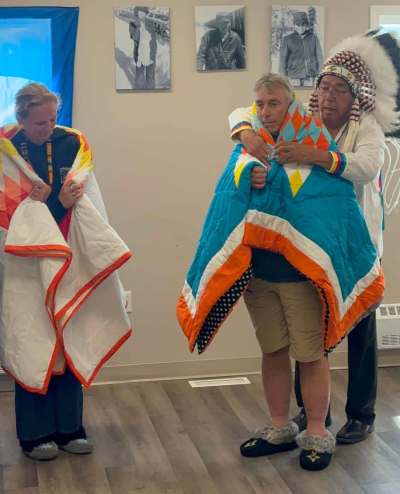 Gry Skjottelvik, left, mother of Steffen Skjottelvik, Atle Lauritzen, centre, his father, and Grand Chief Walter Wastesicoot of Keewatin Tribal Council are pictured in this handout photo in Fox Lake Cree Nation, Man., in July 2026. THE CANADIAN PRESS/Handout - Steffen of Norway Foundation (Mandatory Credit)