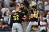 Pittsburgh Pirates catchers Henry Davis (32) and Rafael Flores Jr. keep pitcher Dennis Santana from going after New York Yankees' José Caballero during the ninth inning of a baseball game, Monday, July 20, 2026 in New York. (AP Photo/Noah K. Murray)