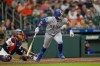 Texas Rangers' Alejandro Osuna, right, watches his RBI single in front of Houston Astros catcher Yainer Diaz during the fourth inning of a baseball game Saturday, Aug. 1, 2026, in Houston. (AP Photo/David J. Phillip)