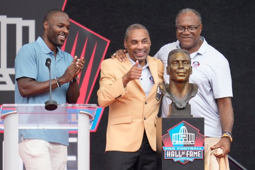 Former NFL player Roger Craig, centre, unveils his bust with son, Roderick Craig, left, and Jamie Williams during the Pro Football Hall of Fame induction ceremony at the Pro Football Hall of Fame, in Canton, Ohio, Saturday, Aug. 8, 2026. (AP Photo/Sue Ogrocki)