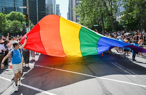 Participants pull a rainbow flag along a street during the Pride parade in Montreal, Sunday, Aug. 10, 2025. THE CANADIAN PRESS/Graham Hughes
