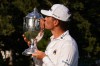 Michael Brennan kisses the trophy after winning the Wyndham Championship golf tournament in Greensboro, N.C., Sunday, Aug. 9, 2026. (AP Photo/Chuck Burton)