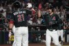 Arizona Diamondbacks' Nolan Arenado, right, celebrates with Tyler Locklear, back left, and Lars Nootbaar (21) after hitting a grand slam against the Colorado Rockies in the second inning of a baseball game, Monday, Aug 10, 2026, in Phoenix. (AP Photo/Rick Scuteri)
