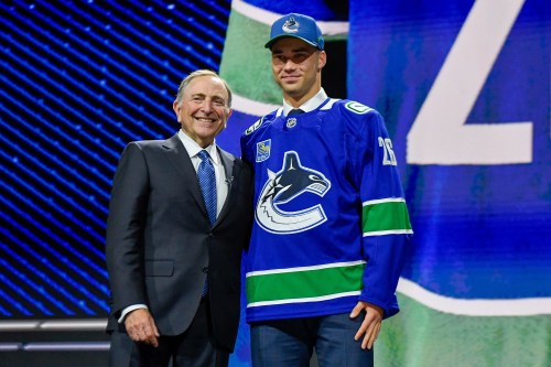 Adam Novotny, right, stands with NHL Commissioner Gary Bettman after being drafted by the Vancouver Canucks during the NHL hockey draft Friday, June 26, 2026, in Buffalo, N.Y. (AP Photo/Adrian Kraus)