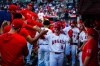 Los Angeles Angels shortstop Zach Neto (9) is greeted by teammates after scoring during the 3rd inning of a baseball game against the Texas Rangers, Tuesday, Aug. 11, 2026, in Anaheim, Calif. (AP Photo/Ethan Swope)