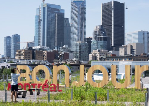 A woman takes a picture of the new Bonjour Montreal in the Old Port Thursday, July 6, 2023 in Montreal.THE CANADIAN PRESS/Ryan Remiorz