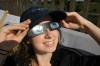 A woman wears safety goggles, as she prepares to watch the partial solar eclipse on the SAYAQ Adventure Tower in Munich's Olympic Park, on Wednesday, Aug. 12, 2026 in Munich, Germany. (Felix Hörhager/dpa via AP)