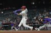 Arizona Diamondbacks' Ketel Marte (4) hits a run-scoring single as Colorado Rockies catcher Brett Sullivan reaches for the ball during the first inning of a baseball game, Wednesday, Aug. 12, 2026, in Phoenix. (AP Photo/Ross D. Franklin)