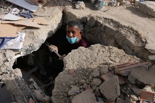FILE - Franklin Fuentes searches for missing relatives in the collapsed building where they lived two days after earthquakes struck La Guaira, Venezuela, June 26, 2026. (AP Photo/Ariana Cubillos, File)