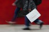 FILE - A person carries a shopping bag in Philadelphia, Dec. 10, 2025. (AP Photo/Matt Rourke, File)