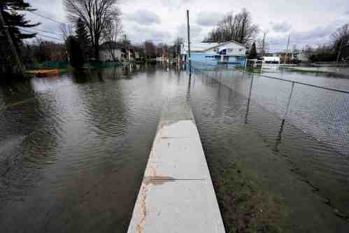 Floodwaters cover the sidewalk on Rue Saint-Louis in Gatineau, Que., on Sunday, April 19, 2026. THE CANADIAN PRESS/Justin Tang