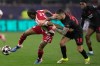 FILE - Leverkusen's Alex Grimaldo holds Olympiacos' Andre Luiz during a Champions League playoff soccer match between Olympiacos and Bayer 04 Leverkusen in Piraeus port near Athens, Feb. 18, 2026. (AP Photo/Thanassis Stavrakis, File)