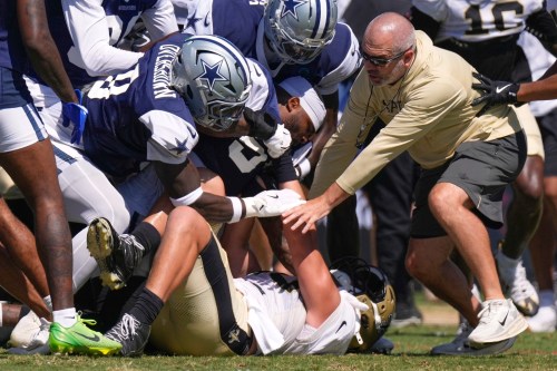 Dallas Cowboys linebacker Demarvion Overshown, left, and outside linebacker Sam Williams, center, fight, with New Orleans Saints tight end Moliki Matavao, below, during an NFL football joint practice, Tuesday, Aug. 18, 2026, in Oxnard, Calif. (AP Photo/Mark J. Terrill)