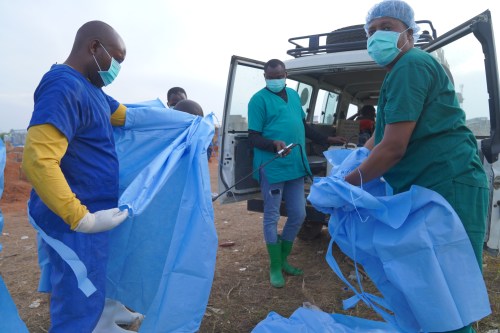 A health worker sprays a colleague with disinfectant after taking part in a burial service for 3-year-old Mave Mercienne, who died of Ebola, in Bunia, Ituri province, eastern Congo, Tuesday, Aug. 18, 2026. (AP Photo/Dieudonne Dirole)
