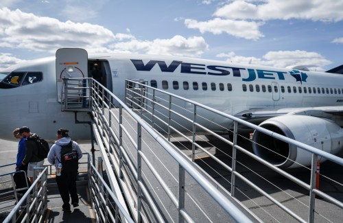 WestJet passengers deplane on the tarmac at Yellowknife Airport on Tuesday, July 22, 2025. THE CANADIAN PRESS/Jeff McIntosh