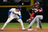 Washington Nationals' CJ Abrams, reaches second for a double ahead of the attempted tag by Texas Rangers' Nicky Lopez as umpire Brian Walsh (60) looks on in the ninth inning of a baseball game Wednesday, Aug. 19, 2026, in Arlington, Texas. (AP Photo/Tony Gutierrez)