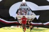 Georgia goalkeeper Jordan Brown (1) leads the team through a banner before the match against James Madison at Sanford Stadium in Athens, Ga, Thursday, Aug. 20, 2026, ahead of a one-off match commemorates the 30th anniversary of the 1996 Olympic women's soccer gold-medal match played at Sanford Stadium. (Evan Frilingos/The Red & Black via AP)