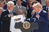 President Donald Trump puts a championship ring into his pocket as owner Mark Walter presents him with a jersey during an event to honor the 2025 World Series champions Los Angeles Dodgers in the Rose Garden of the White House, Thursday, July 23, 2026, in Washington. (AP Photo/Alex Brandon)
