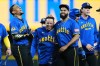 Seattle Mariners' Leo Rivas, center, celebrates with teammates Julio Rodríguez, left, and Seranthony Domínguez, third from left, after his walk-off RBI single in the 10th inning to win a baseball game against the Chicago Cubs, Friday, Aug. 21, 2026, in Seattle. (AP Photo/Lindsey Wasson)