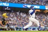 Los Angeles Dodgers' Max Muncy, right, hits a two-run home run as Pittsburgh Pirates catcher Rafael Flores Jr. watches during the first inning of a baseball game Friday, Aug. 21, 2026, in Los Angeles. (AP Photo/Mark J. Terrill)