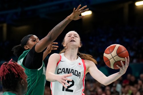 Syla Swords (12), of Canada, shoots in front of Elizabeth Balogun (4), of Nigeria, in a women's basketball game at the 2024 Summer Olympics, Sunday, Aug. 4, 2024, in Villeneuve-d'Ascq, France. (AP Photo/Mark J. Terrill)