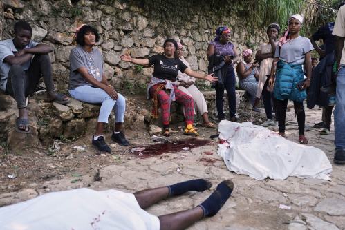 People gather next to the bodies of people they said were their relatives and were killed in a gang attack in the Kenscoff neighborhood of Port-au-Prince, Haiti, Monday, Aug. 24, 2026. (AP Photo/Odelyn Joseph)