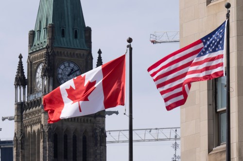 Canadian and United States flags are seen flying near Parliament Hill, Wednesday, March 22, 2023 in Ottawa. THE CANADIAN PRESS/Adrian Wyld