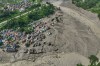 Damaged houses stand precariously near the swollen, debris-choked banks of the Trishuli River after flash floods in Nepal's Nuwakot district on Wednesday, Aug. 26, 2026. (AP Photo/Niranjan Shrestha)