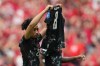 Canada's Nathan Saliba (25) holds up the jersey of teammate Ismael Kone, who suffered an injury earlier in the half, in tribute after scoring on a free kick during second half World Cup Group B soccer action against Qatar, in Vancouver, Thursday, June 18, 2026. THE CANADIAN PRESS/Ethan Cairns