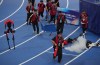 Officials extinguish a fire of a Humanoid robot after hitting the barrier at the end of the 100 meter final race during the World Humanoid Robot Games in Beijing, Wednesday, Aug. 26, 2026. (AP Photo/Achmad Ibrahim)