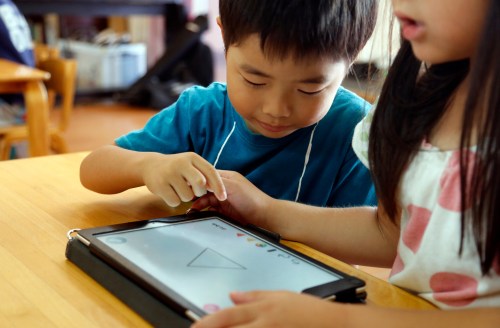 FILE - Children work on a digital program at Coby Preschool in Yoshikawa, suburban Tokyo, July 12, 2018. (AP Photo/Yuri Kageyama, File)