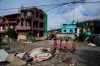 People walk past damage in the aftermath of flash floods in Devighat in the Nuwakot district in Nepal, Thursday, Aug 27, 2026. (AP Photo/Niranjan Shrestha)
