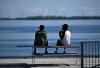 People enjoy the warm weather on the Gord Edgar Downie Pier at Lake Ontario in Kingston, Ont., on Thursday, May 16, 2024. THE CANADIAN PRESS/Justin Tang