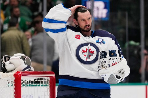 FILE - Winnipeg Jets goaltender Connor Hellebuyck stands by the net during a time out from play against the Dallas Stars in the first period of an NHL hockey game, April 2, 2026, in Dallas. (AP Photo/Tony Gutierrez, File)