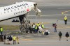 Officials inspect the wreckage of an Air Canada Express jet, Wednesday, March 25, 2026, just off the runway where it had collided with a Port Authority fire truck Sunday night at LaGuardia Airport in New York. (AP Photo/Yuki Iwamura)