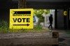 A vote sign is posted as a person enters a polling station in the Vancouver East riding on federal election day in Vancouver., on Monday, April 28, 2025. THE CANADIAN PRESS/Ethan Cairns