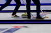 Athletes sweep the ice as a curling stone slides down the sheet before the bronze-medal game between the United States and Scotland at the world men's curling championship on April 4, 2026, in Ogden, Utah. (AP Photo/Tyler Tate)