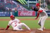 Los Angeles Angels' Mike Trout, left, scores on wild pitch by Philadelphia Phillies starting pitcher Andrew Painter, left, as Painter takes a late throw during the first inning of a baseball game Friday, Aug. 28, 2026, in Anaheim, Calif. (AP Photo/Mark J. Terrill)