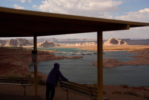 FILE - A person stands at an overlook near the Wahweap Marina on Lake Powell at the Glen Canyon National Recreation Area, July 15, 2026, near Page, Ariz. (AP Photo/John Locher, File)