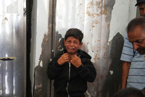 A Palestinian boy cries over the body of Hamouda al-Attar, who was killed by the Israeli army, during his funeral at al-Aqsa Hospital in Deir al-Balah, central Gaza Strip, Saturday, Aug. 29, 2026. (AP Photo/Abdel Kareem Hana)